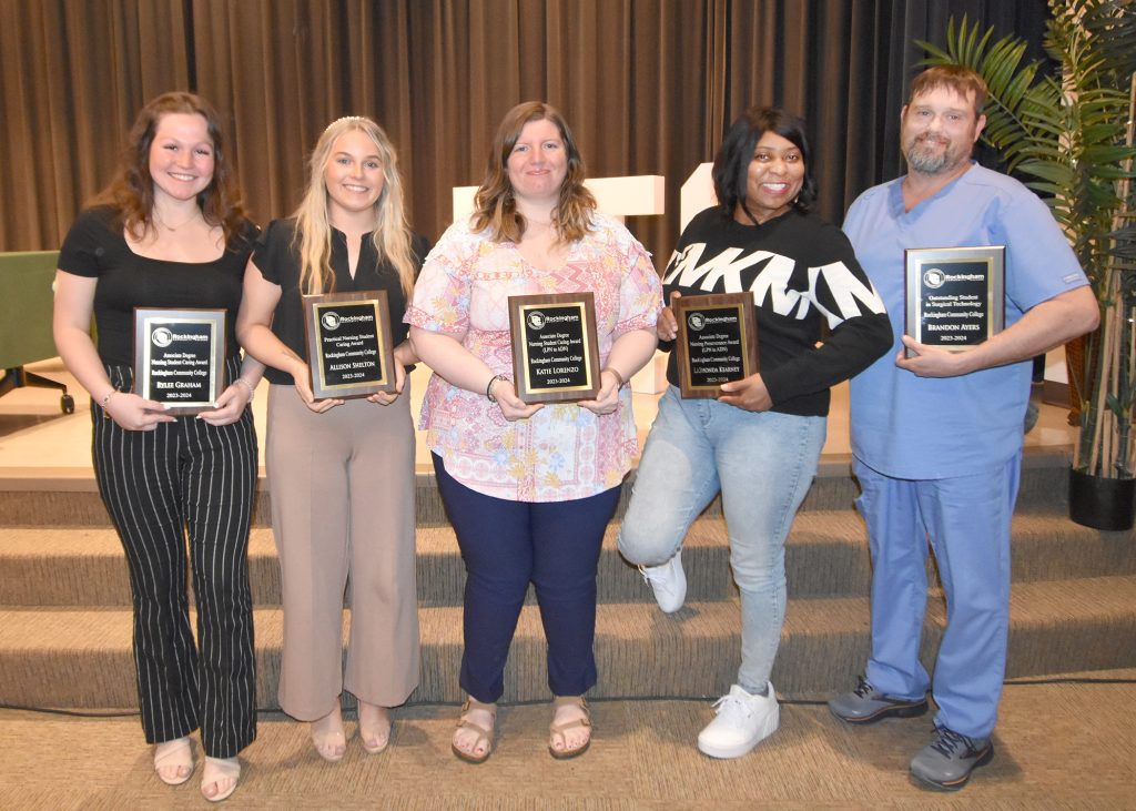 Picture of five students holding plaques.