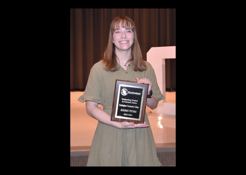 Picture of a student holding a plaque.