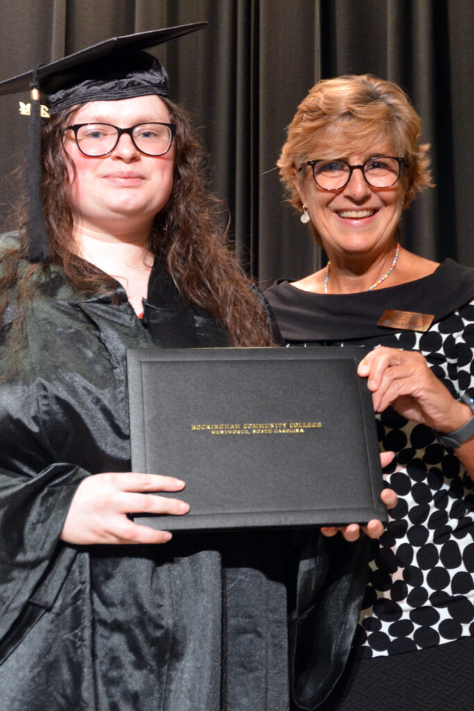 A GED graduate and college administrator smile.