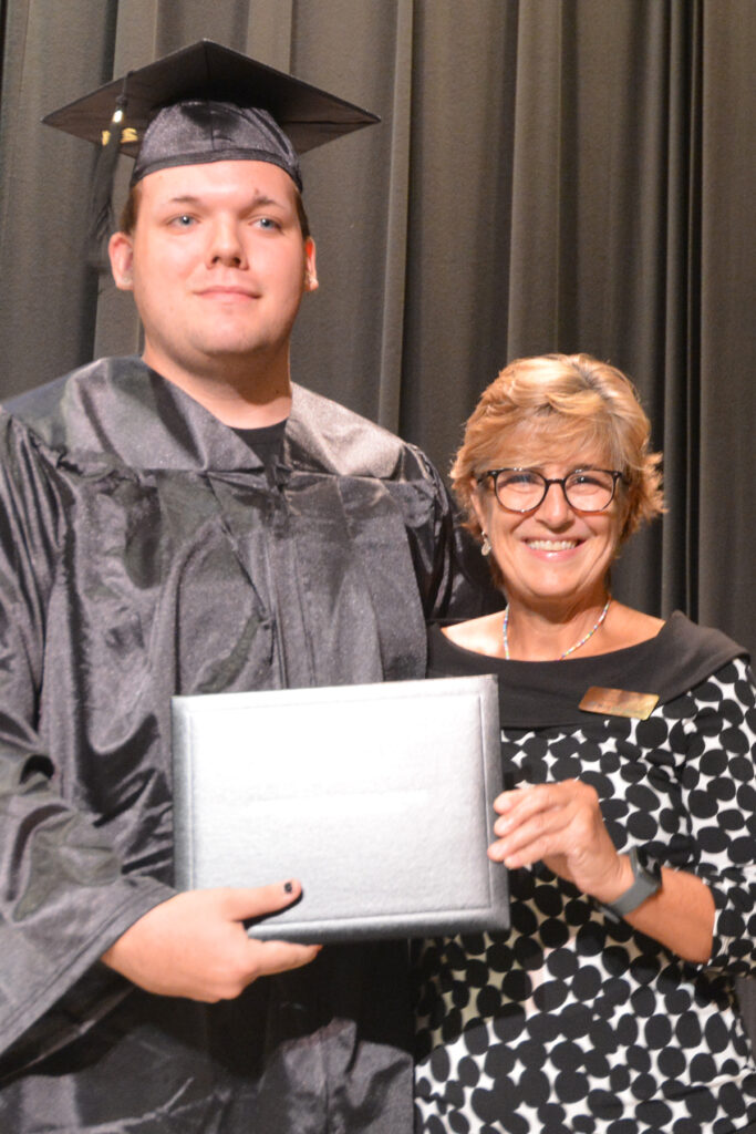 A GED graduate and college administrator smile.