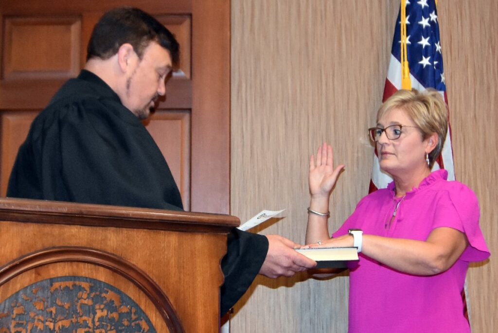 Clerk of Court administers oath of office to a woman.