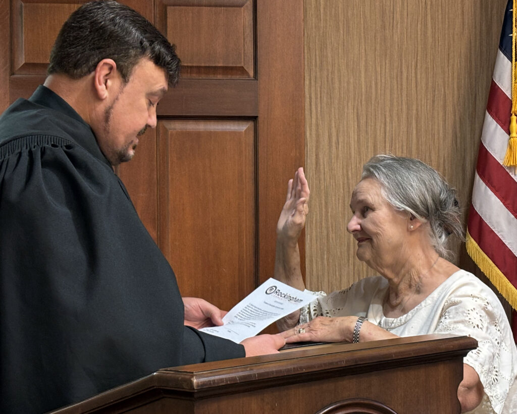 Clerk of Court administers oath of office to a woman.