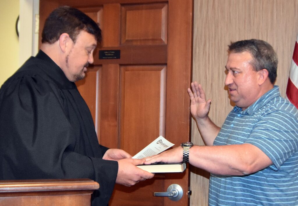 Clerk of Court administers oath of office to a man.