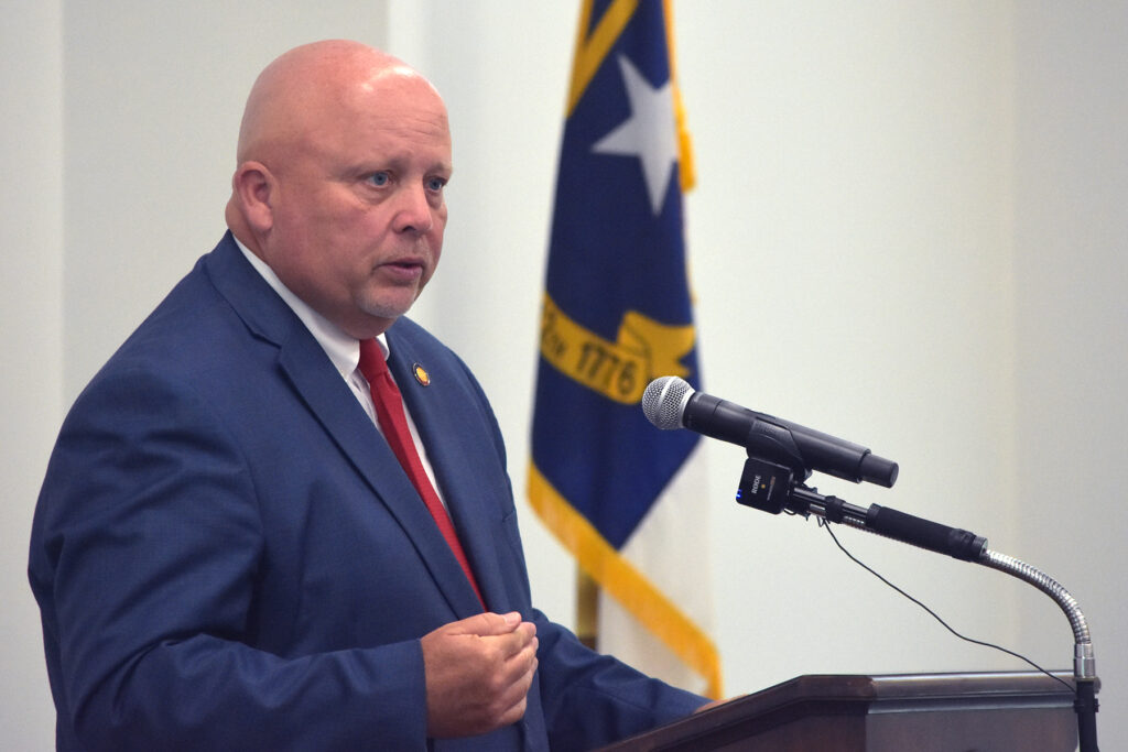 A man talks at podium.