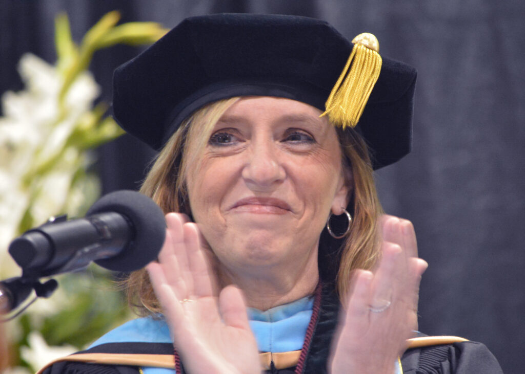 A woman claps and smiles.