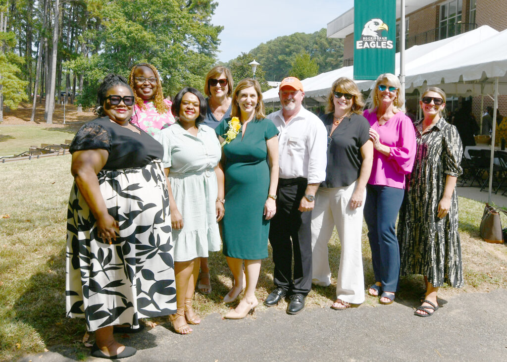 A group of people smile outside.