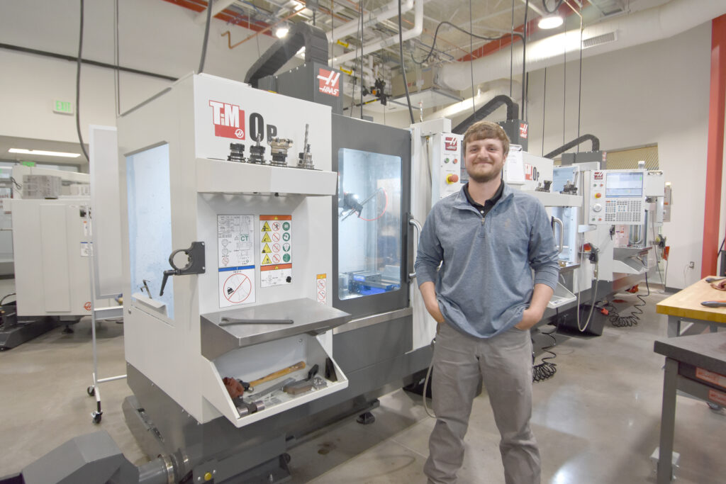 A man stands in a computer-integrated machining lab on a college campus.