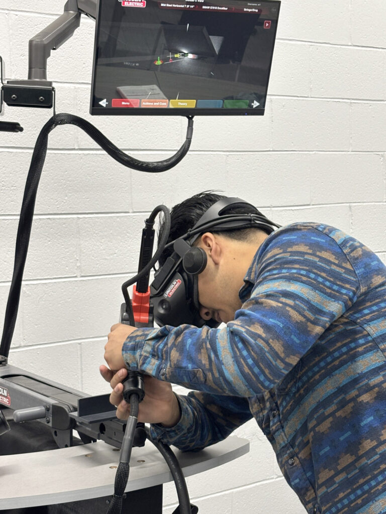 Man wearing a virtual reality mask uses a welding simulator