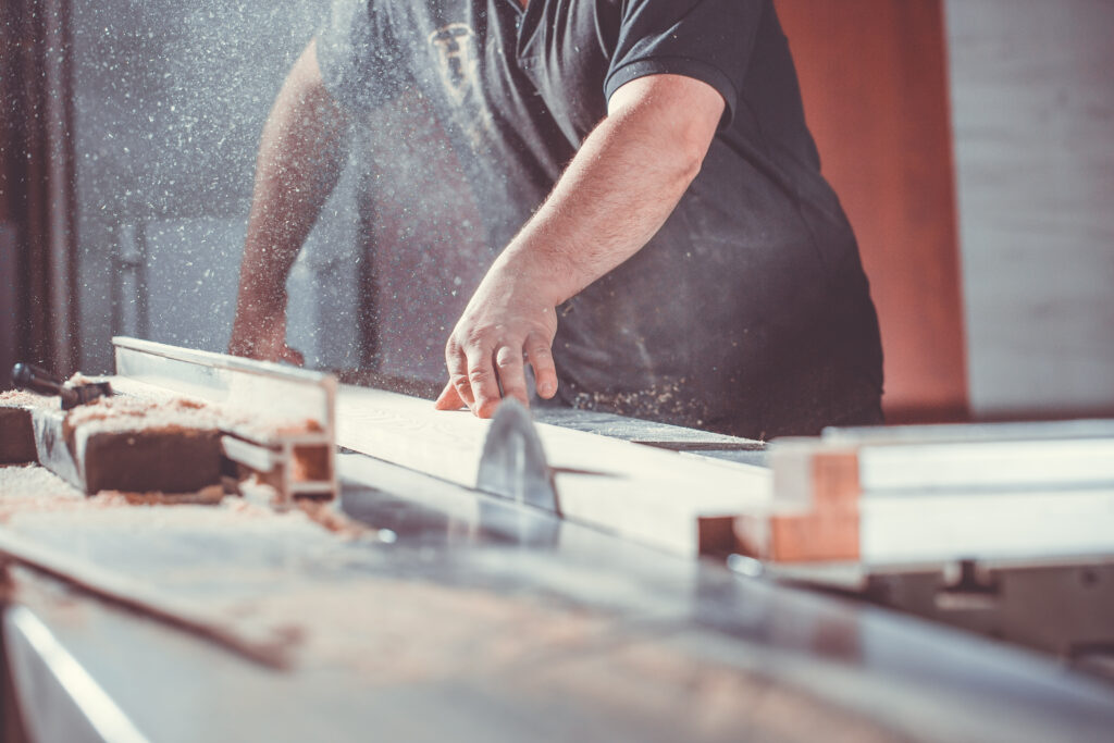 Woodworker using a table saw to cut wood