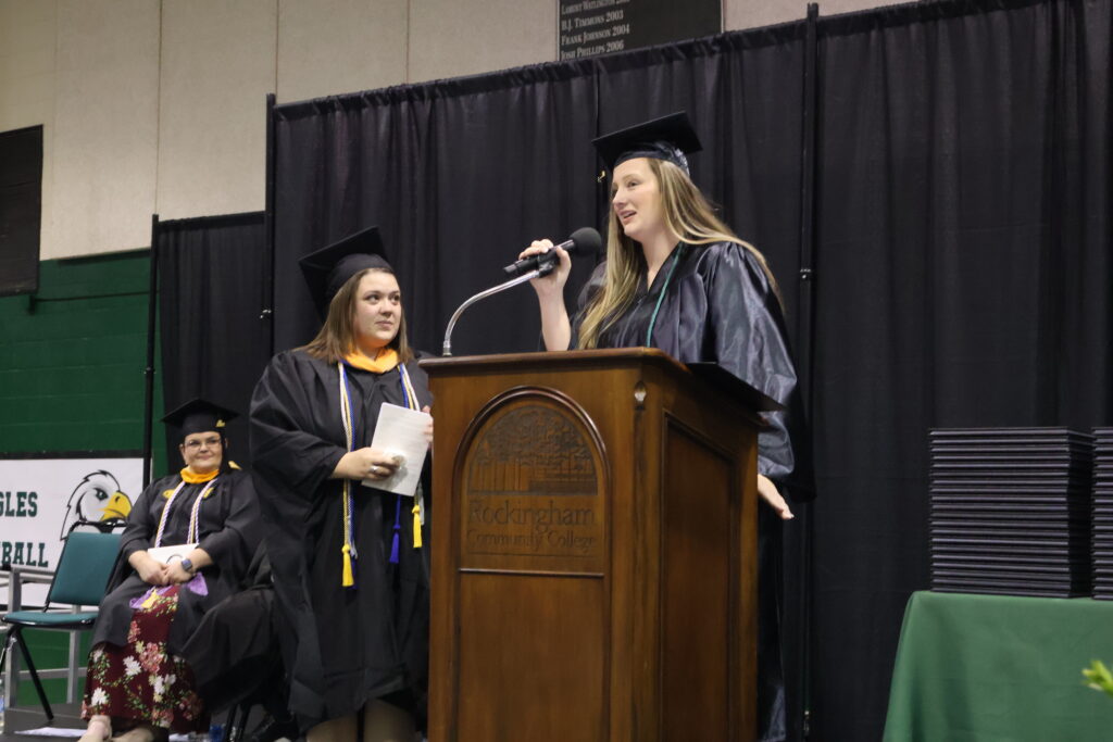 Outstanding Student of the Year Laura Palmer speaks at a podium during the graduation ceremony.