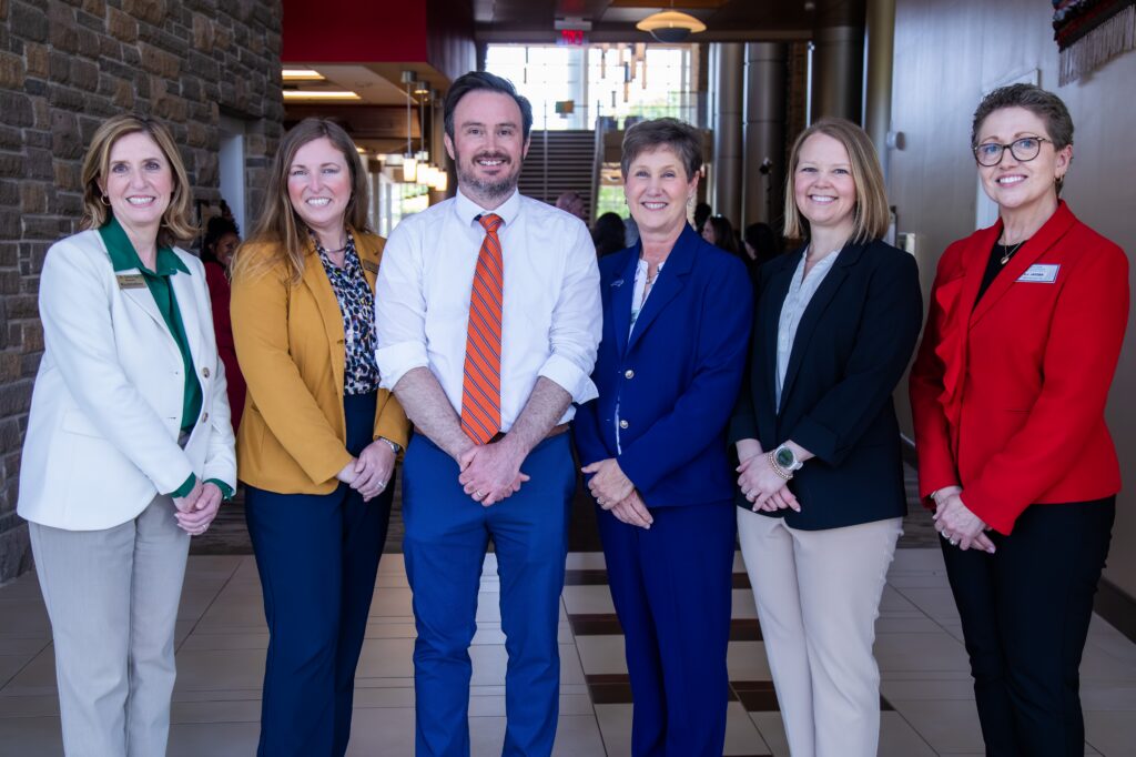 A man and five women pose for a photo.