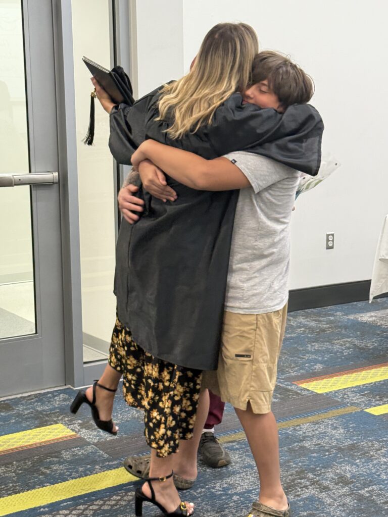 CCR graduation hugging a family member.