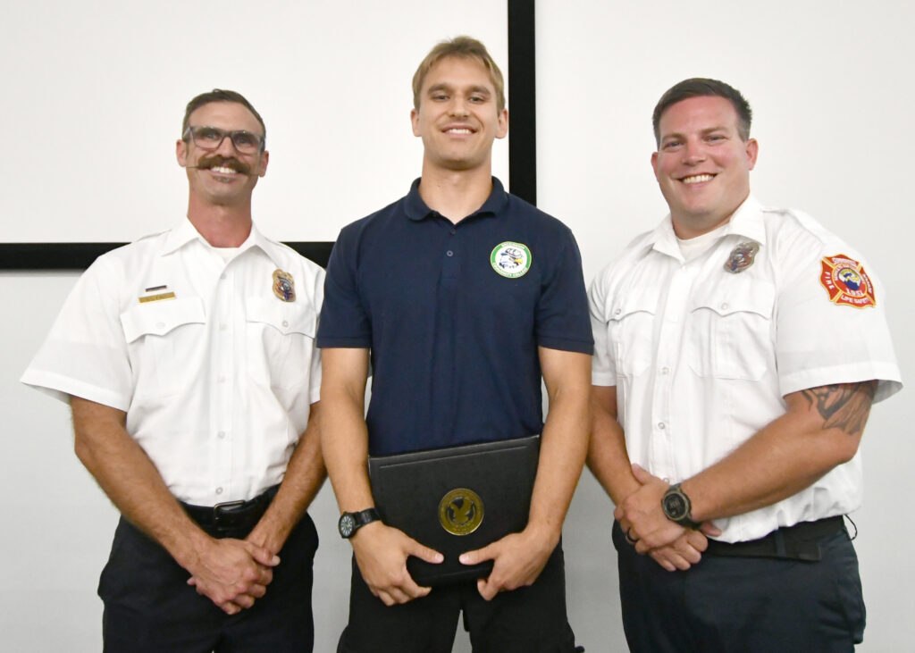 A Fire Academy graduate and two instructors.