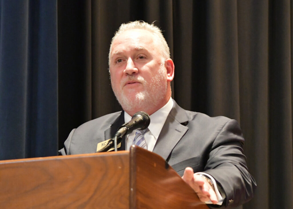 A man speaks at a podium.